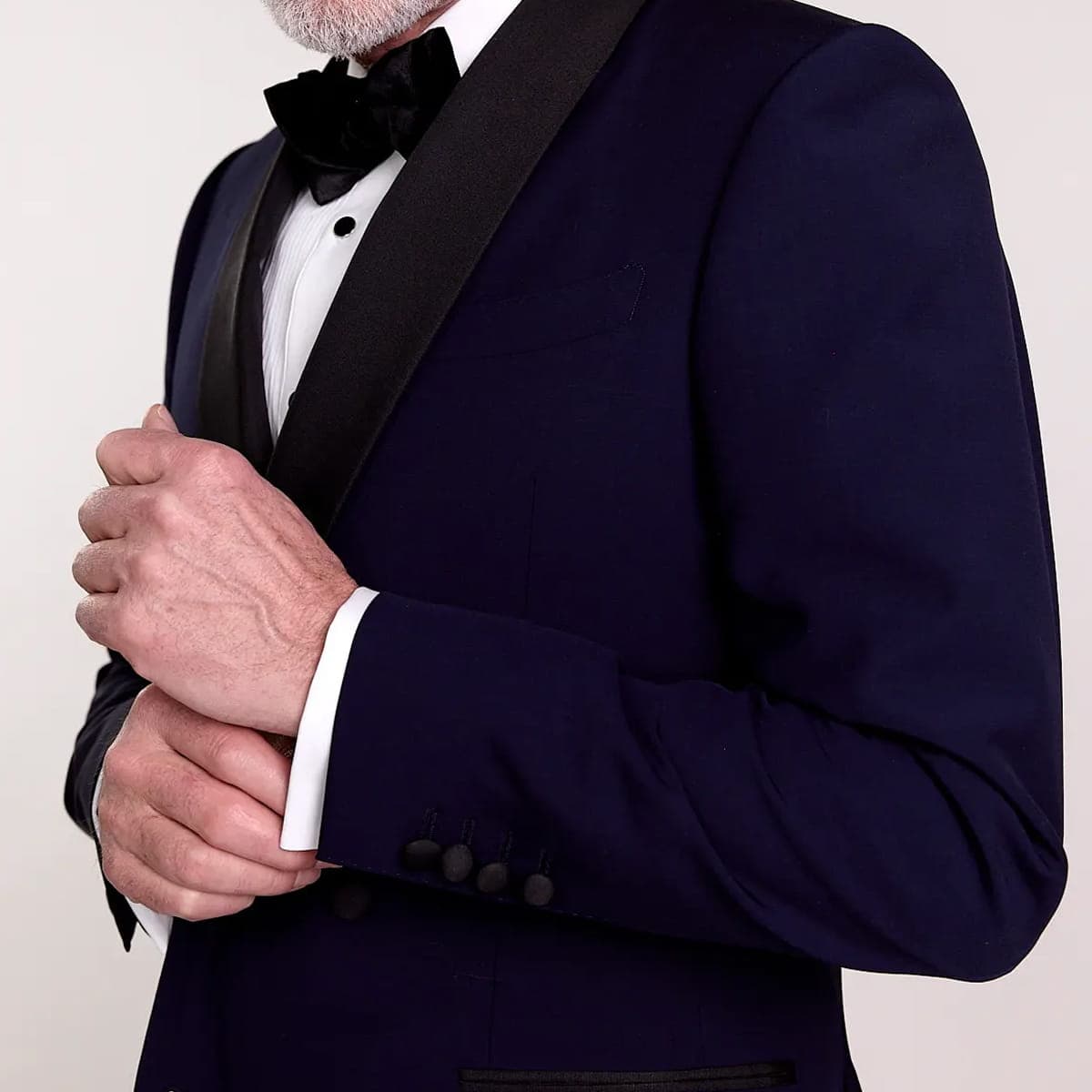 Groomsman adjusting his cuff in a navy tuxedo