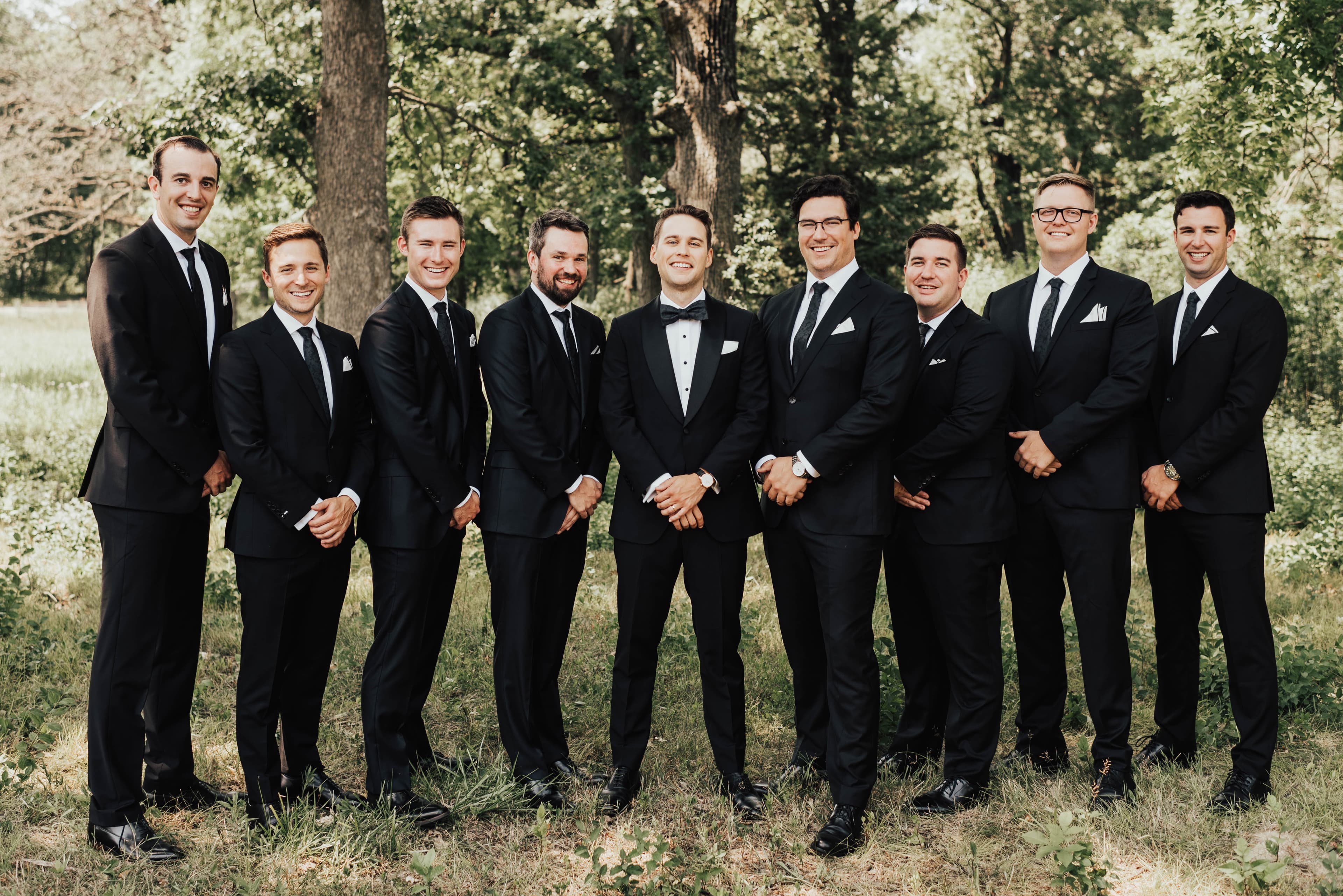 Full wedding party of groomsmen standing together